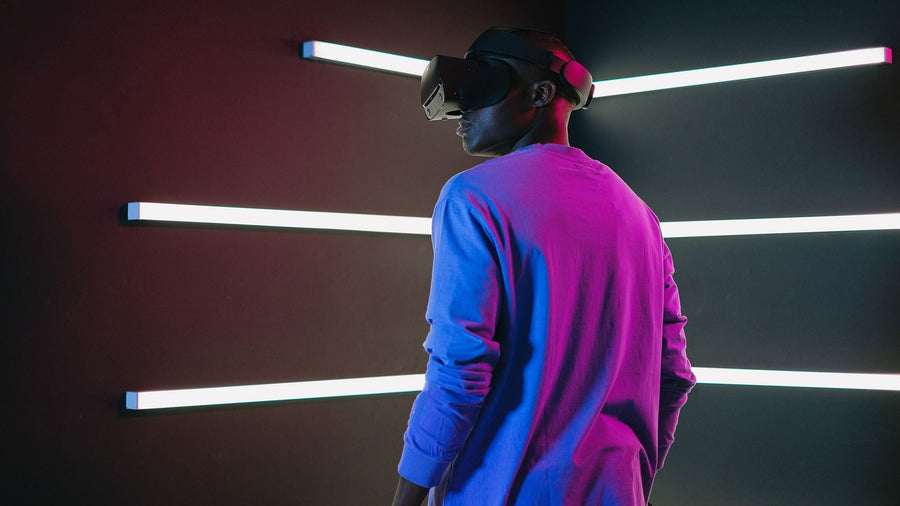 A person wearing a VR headset in a dark room lined with light bars