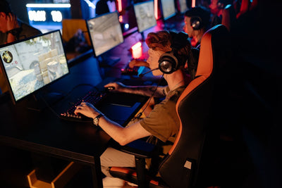 Esports players in headsets competing at a row of gaming computers